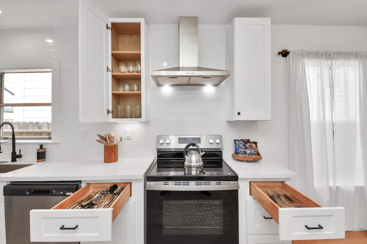 Kitchen with range and stocked utensil drawer