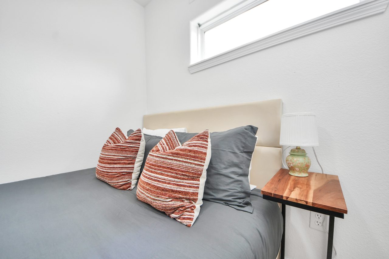Bedroom with layered pillows and nightstand