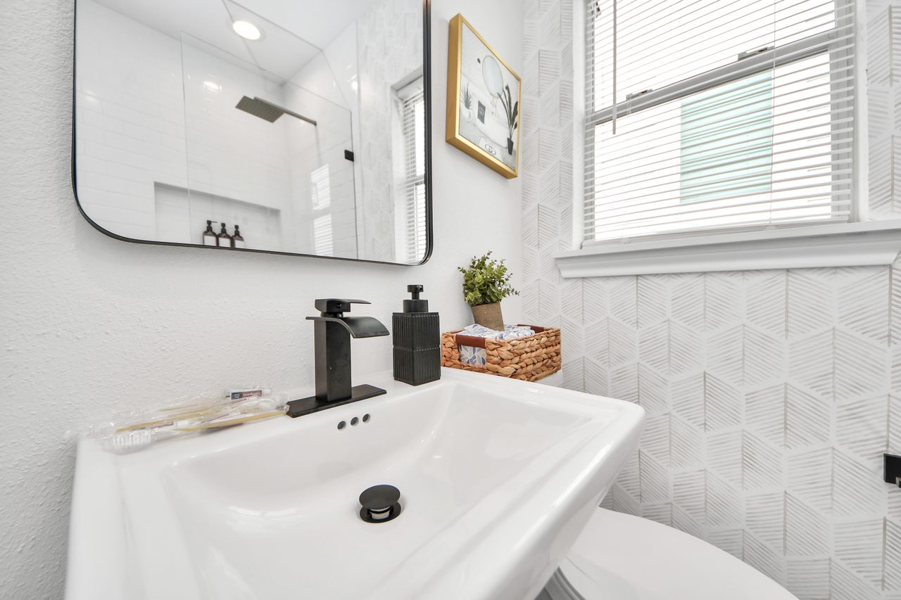 Bathroom pedestal sink and framed mirror